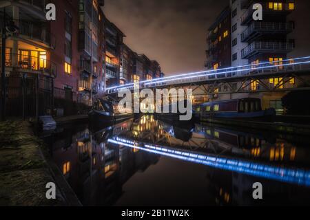 Nachtaufnahme von Sherborne Wharf in Birmingham, Großbritannien mit Lichtreflexionen im Kanalwasser Stockfoto