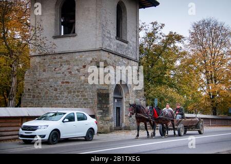 Arbore, RUMÄNIEN - 07. OKTOBER 2014: Pferdekutsche mit Unbekannten, die an orthodoxen Klöstern der Bucovina vorbeiziehen. Kloster Arbore, erbaut im 1 Stockfoto