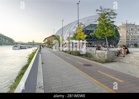 Budapest, Ungarn - 13. September 2019: Balna oder Whale modernes Einkaufs- und Kulturzentrum am Flussufer der Donau - Freiheitsbrücke in der Ferne. Stockfoto