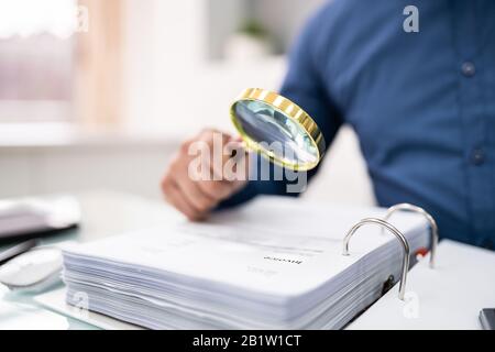 Geschäftsmann Dokument durch Lupe betrachten Stockfoto