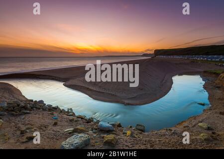 Burton Bradstock, Dorset, Großbritannien. Februar 2020. Wetter in Großbritannien. Sonnenuntergang vom South West Coast Path über den Fluss Bride am Süßwasserstrand von Burton Bradstock in Dorset am Ende eines sonnigen Tages. Bildnachweis: Graham Hunt/Alamy Live News Stockfoto