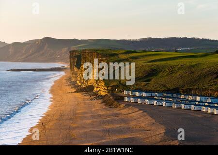 Burton Bradstock, Dorset, Großbritannien. Februar 2020. Wetter in Großbritannien. Blick am Strand und an den Klippen, Blick auf West Bay in Dorset vom South West Coast Path am Süßwasser in Burton Bradstock in Dorset kurz vor Sonnenuntergang am Ende eines sonnigen Tages. Die Erosion durch das jüngste schlechte Wetter hat einen großen Felssturz verursacht, der an der Basis der Klippen sitzt. Bildnachweis: Graham Hunt/Alamy Live News Stockfoto