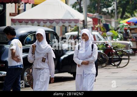 Verschleierte indonesische muslimische Studentinnen mit Uniform in der Nachbarschaft von Batavia in Jakarta - Java, Indonesien. Altstadt von Batavia in Jakarta. Stockfoto