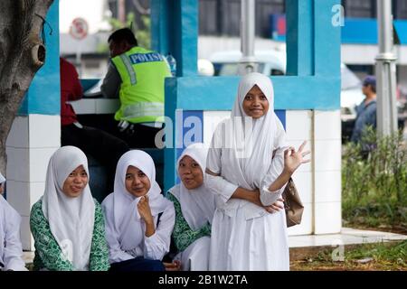 Verschleierte indonesische muslimische Studentinnen mit Uniform in der Nachbarschaft von Batavia in Jakarta - Java, Indonesien Stockfoto