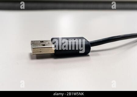 Das Ende eines schwarzen USB-Kabels mit einem Stecker. Stockfoto