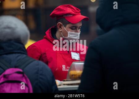 Moskau, Russland. Am 27. Februar 2020 Tragen Mitarbeiter in Fast-Food-Restaurants auf der Messe Maslenitsa während einer sich ausbreitenden Nachricht über epidemisches Coronavirus in der Welt in Moskau, Russland medizinische Masken. Moskaus Rospotrebnadzor verstärkt Maßnahmen zur Vorbeugung der Coronavirus-Epidemie. Dazu werden die Mitarbeiter von Restaurants und anderen öffentlichen Gastronomiebetrieben aufgefordert, Masken zu tragen, Geschirr zu desinfizieren und in den Hallen bakterielle Lampen zu installieren Stockfoto