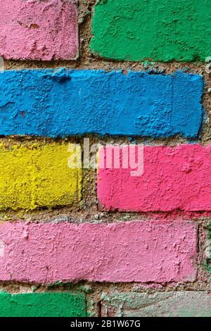 Ziegelwand in verschiedenen Farben bemalt. Vertikal. Nahaufnahme. Stockfoto