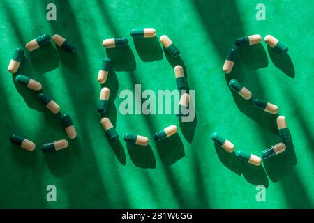 Grüne und weiße pharmazeutische Medikamente, die das Wort SOS bilden. Nahaufnahme Stockfoto