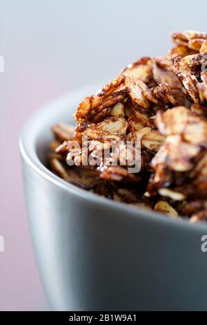 Makroschuss aus hausgemachter Kakaogranola mit knackigen Erdnüssen und Ahorn-Sirup. Morgenlicht, hohe Auflösung Stockfoto