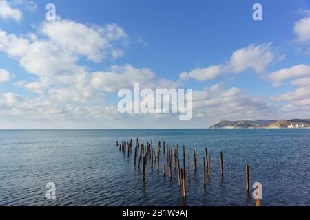 Die Überreste des zerstörten Piers im Meer. Russland, Krasnodar Krai, Dorf des großen Utrischs. Sonniger Tag Stockfoto