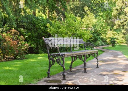 Schöne schmiedeeiserne Bank im Park Paradise. Sommertag. Partenit, Krim, Russland Stockfoto