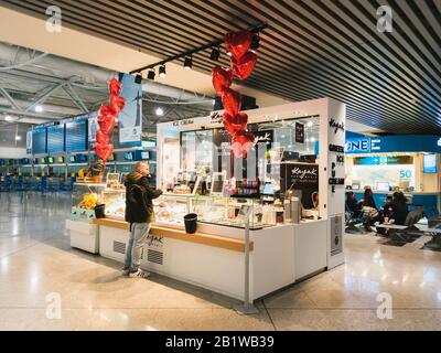 Athen, Griechenland - Februar, 11 2020: Ein Passagier, der im Kayak Pure Magic greek Tiefkühljoghurt und Eiscafé im Hauptterminal von bestellt Stockfoto