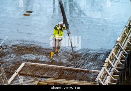 Baustelle, Betonierung, Boden, Decke für ein Gebäude wird betoniert, der Beton auf die Stahlbetonmatten gepumpt, Stockfoto