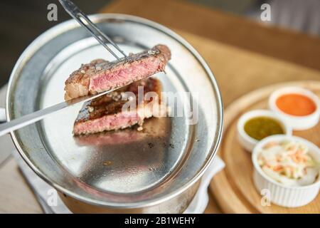 Der Kellner Schnitt Gegrillte Striploin-Steaks. Das Streifensteak, auch New Yorker Streifen genannt. Grillrestaurant Menü. Stockfoto