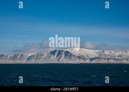 Kostenlinie mit schneebedeckten Bergen in Island Stockfoto