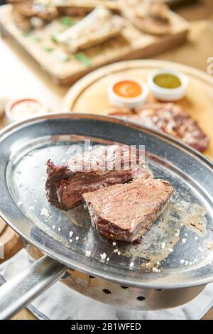 Gegrilltes Filet Steaks. Ein Stück Fleisch, das in zwei Stücke geschnitten wurde. Grillrestaurant. Auf einer Metallplatte mit Kohle. Chateaubriand Steak Stockfoto