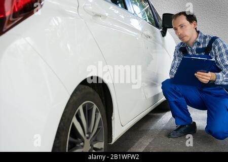 Insurance Agent Inspection White Car Paint Auf Kratzer Stockfoto