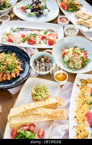 Viele verschiedene köstliche Gerichte auf dem Tisch. Verschiedene Snacks und Antipasti auf dem Tisch. Restaurant-Menü. Italienische Küche Stockfoto