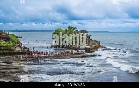 Besucher und Pilger in Tanah Lot, einer Felsformation vor der indonesischen Insel Bali, wo sich ein alter hinduistischer Pilgertempel Pura Tanah Lot, Bal, befindet Stockfoto