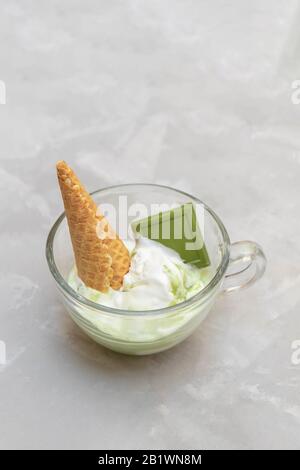 Matcha affogato mit grünem Tee und Vanilleeis auf neutralem Hintergrund Stockfoto