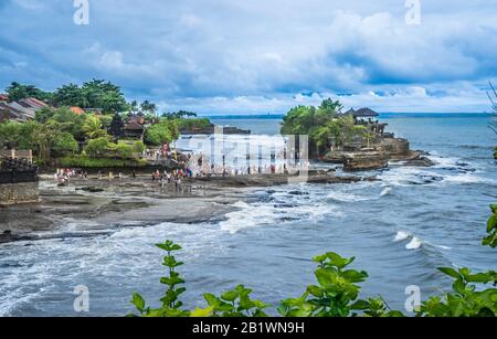 Besucher und Pilger in Tanah Lot, einer Felsformation vor der indonesischen Insel Bali, wo sich ein alter hinduistischer Pilgertempel Pura Tanah Lot, Bal, befindet Stockfoto