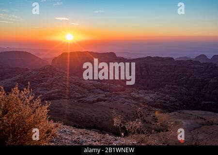 Schöne Landschaft. Blick auf die Berge bei Sonnenuntergang über den Wüstenbergen im Wadi Musa, Haschemite Königreich Jordanien. Der Rand zwischen den goldenen und blauen Stunden Stockfoto