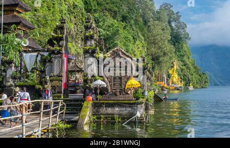 Pura Tirta Hulundanu hindutempel am Ufer des Batur-Sees mit der vergoldeten Statue von Dewi Danu, der im Hintergrund liegenden Meeresgottheit Kintaman Stockfoto