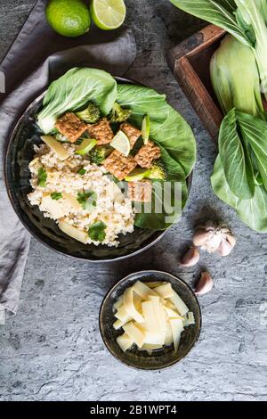 Tempeh mit Reis, bok Choy, gedämpften Brokkoli und Bambusprossen auf einem Teller Stockfoto