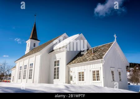 Hattfjelldal-Kirche, Norwegen. Sehr sonniger Tag, viel Schnee, sehr tiefblauer Himmel und fast keine Wolken, Seitenansicht Stockfoto