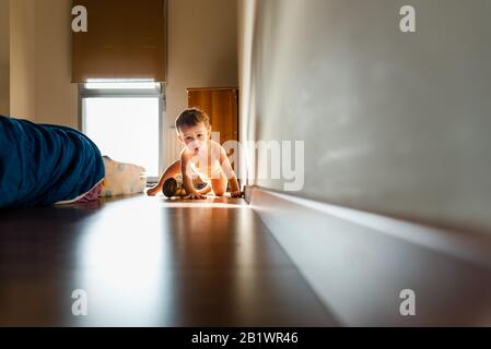 Baby krabbeln auf dem Fußboden seines Schlafzimmers. Stockfoto