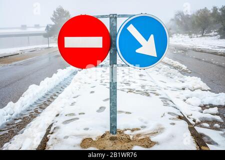 Wegweiser auf schneebedeckter Straße im Winter verboten. Stockfoto