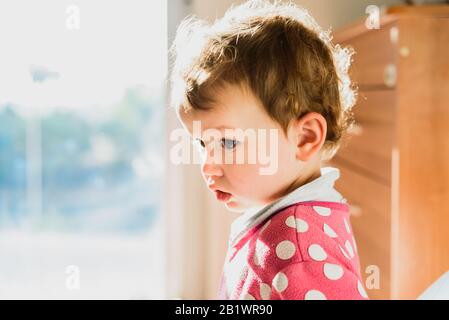 Portrait von liebenswürdig geborenem Mädchen mit Hintergrundbeleuchtung ein warmer Morgen in seiner Entwicklung. Stockfoto