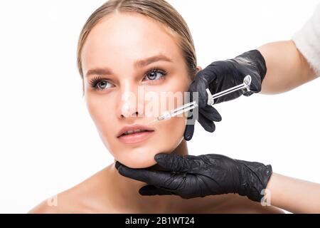 Portrait der jungen Frau, die eine kosmetische Injektion erhält. Nahaufnahme der schönen Frau wird ins Gesicht gespritzt. Stockfoto