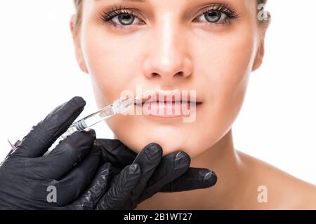Portrait der jungen Frau, die eine kosmetische Injektion erhält. Nahaufnahme der schönen Frau wird ins Gesicht gespritzt. Stockfoto