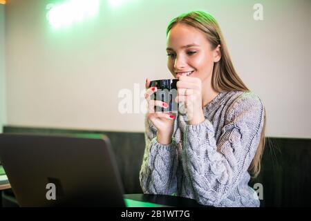 Schöne fröhliche Frau Freiberuflerin mit guter Laune mit Laptop Computer für Fernarbeiten beim Mittagessen in der Café-Bar, attraktive Frau mit schönen s Stockfoto