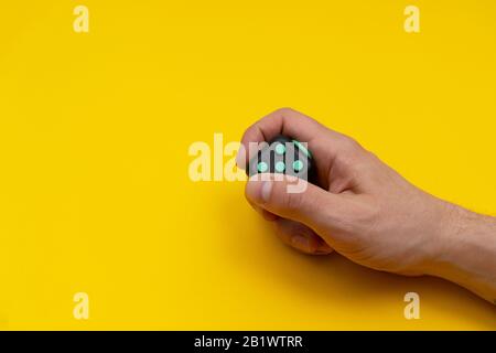 Antistress Fidget in bemannt rechte Hand auf gelbem Hintergrund Stockfoto