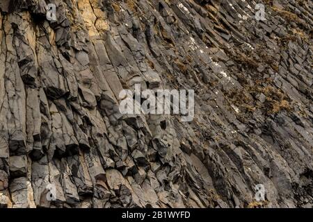 Details zu sechseckigen Basaltsäulen der Felswand von Garðar im Reynisfjara-Strand (Island). Stockfoto