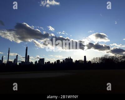 New York City, New York, Vereinigte Staaten. Februar 2020. Dramatische Wolken bilden sich während des Sonnenuntergangs über dem Gebäude von Midtown Manhattan vom Great Lawn im Central Park an einem blutrigen und kalten Tag in New York City aus. Credit: Adam Stoltman/Alamy Live News Stockfoto