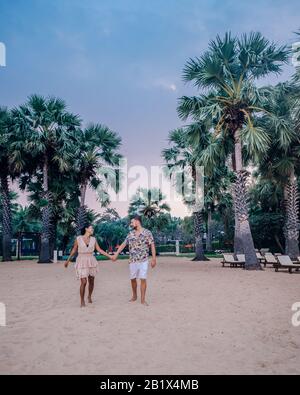 NaJomtien Pattaya Thailand, Paar Männer und Frauen, die während des Sonnenaufgangs in Pattaya Thailand am Strand spazieren Stockfoto