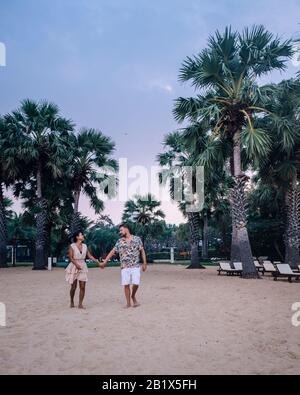 NaJomtien Pattaya Thailand, Paar Männer und Frauen, die während des Sonnenaufgangs in Pattaya Thailand am Strand spazieren Stockfoto