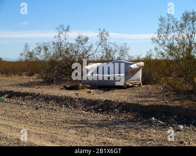 Eine alte Couch in der Nähe einer Schulbushaltestelle entlang einer abgelegenen Straße in Arizona, auf der die Schüler sitzen, während sie auf ihre Fahrt zur Schule warten. Stockfoto