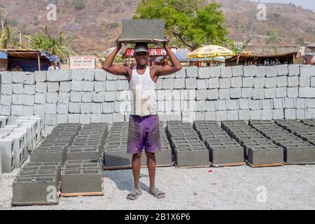 Ein Mann legte in einer Fabrik in Abuja, Nigeria, Ziegelsteine aus. Stockfoto
