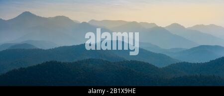 Atemberaubend wilder Blick auf die Bergwaldlandschaft mit bewölktem Himmel. Natürliche grüne Landschaft mit Wolke und Berghängen Hintergrund. Maehong Stockfoto