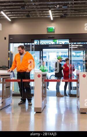 Am 27. Februar 2020 scannt ein Kunde sein Handy, um Amazon Go Grocery zu besuchen. Der erste große, kashierlose Supermarkt des Technikunternehmens wurde Anfang der Woche im Viertel Capitol Hill in Seattle eröffnet. Kunden scannen eine Amazon Go App, um in den 10.000 Quadratfuß großen Laden zu gehen, die Produkte zu nehmen und ohne Auschecken zu gehen. Die "Just Walk Out Technology" von Amazon nutzt ein komplexes System von Kameras und Sensoren, um Einkäufe nachzuverfolgen, das bereits in ihren kleineren Amazon Go Convenience Stores verwendet wird. Stockfoto