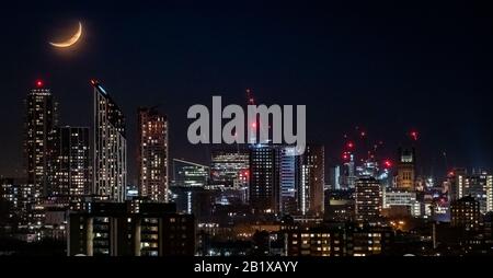 London, Großbritannien. Februar 2020. Wetter in Großbritannien: Ein Wachender Halbmond geht am Donnerstagabend 21:20 in nordöstlicher Richtung über die Stadt. Credit: Guy Corbishley/Alamy Live News Stockfoto