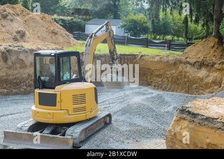 Bagger graben Schaufel schaufeln Kies von im Gebäude Stiftung Stockfoto