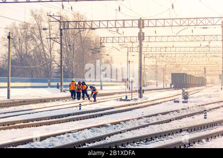 Kemerovo, Russland - märz 2019 Kleinbahnhof mit Arbeitern an einem Wintermorgen oder -Abend auf den Gleisen. Stockfoto