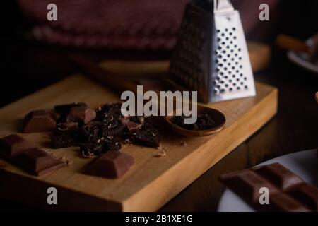 Schokoladenspanstücke mit Schokoladenstücken auf Schneidebrett mit Holzlöffel Stockfoto