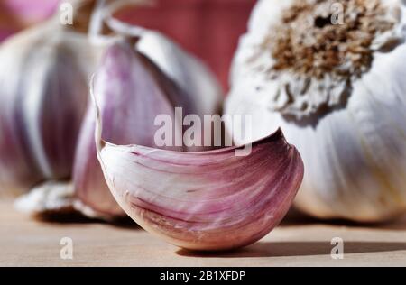 Schöne weiße - lila Knoblauchzehe auf Holztisch im Hintergrund Knoblauchzwiebeln Stockfoto