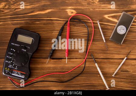 Set zum Löten von Draht und Schrumpflötschlauch mit Lötmittel neben Schraubendreher und Multimeter auf Holzhintergrund, Funk-Elektronik-Konzept Stockfoto